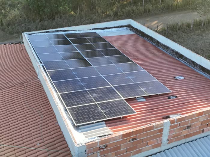 Placas solares em telhado ao lado da caixa d'água da casa