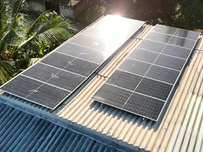Placas solares alinhadas sobre telhado de fibrocimento