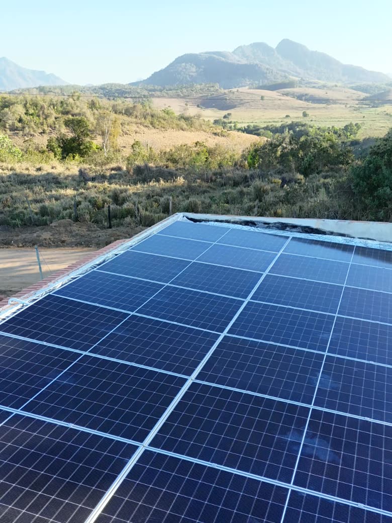 Usina solar instalada em propriedade rural, com a serra capixaba ao fundo
