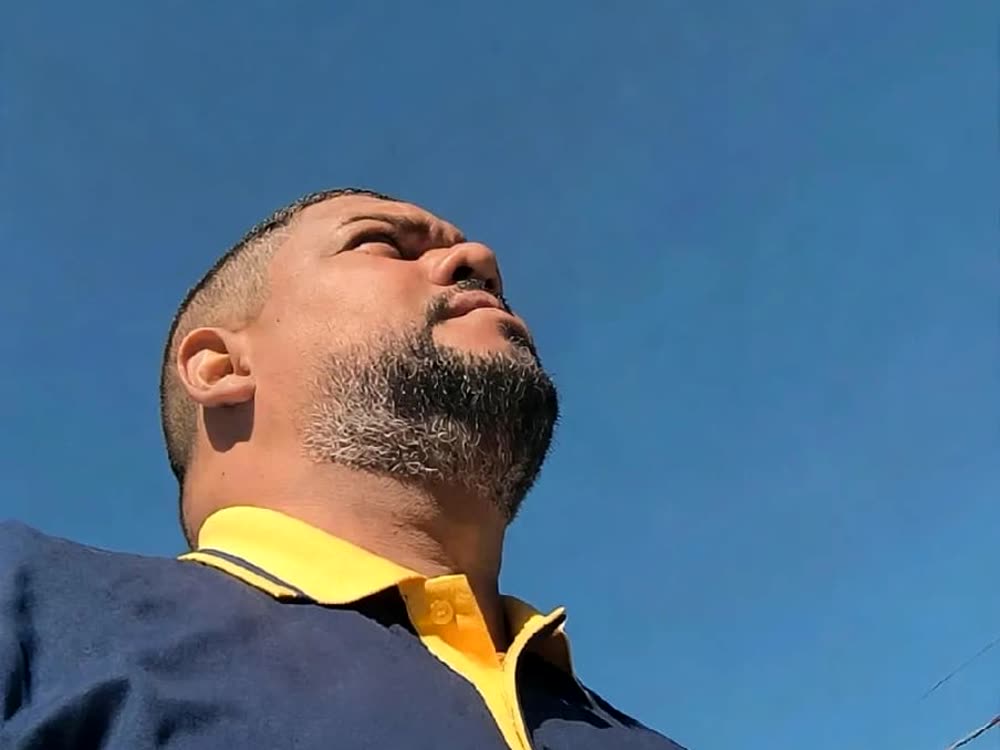 Profissional da W.U de uniforme, olhando para o céu aberto